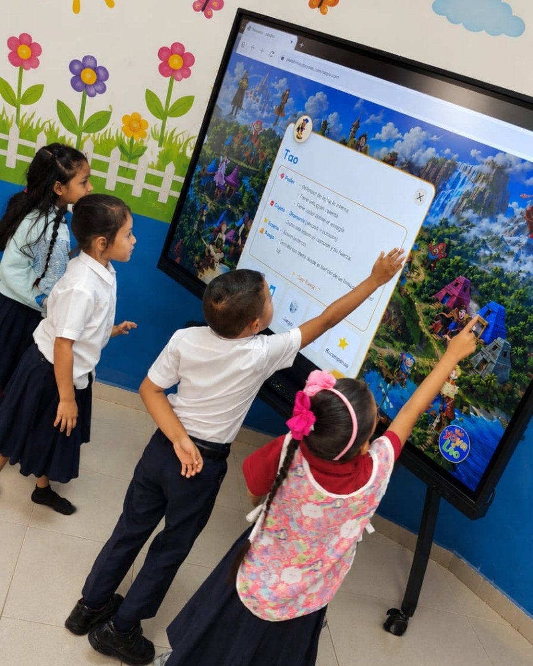Niños abriendo la ficha de un personaje en la pantalla interactiva