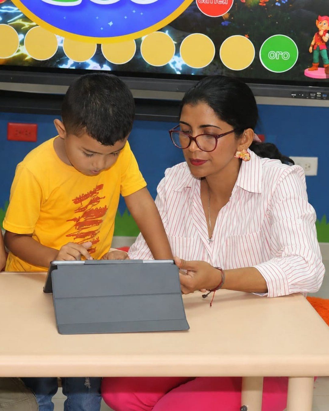 Dayana Pitty acompañando a un niño que trabaja en la tableta