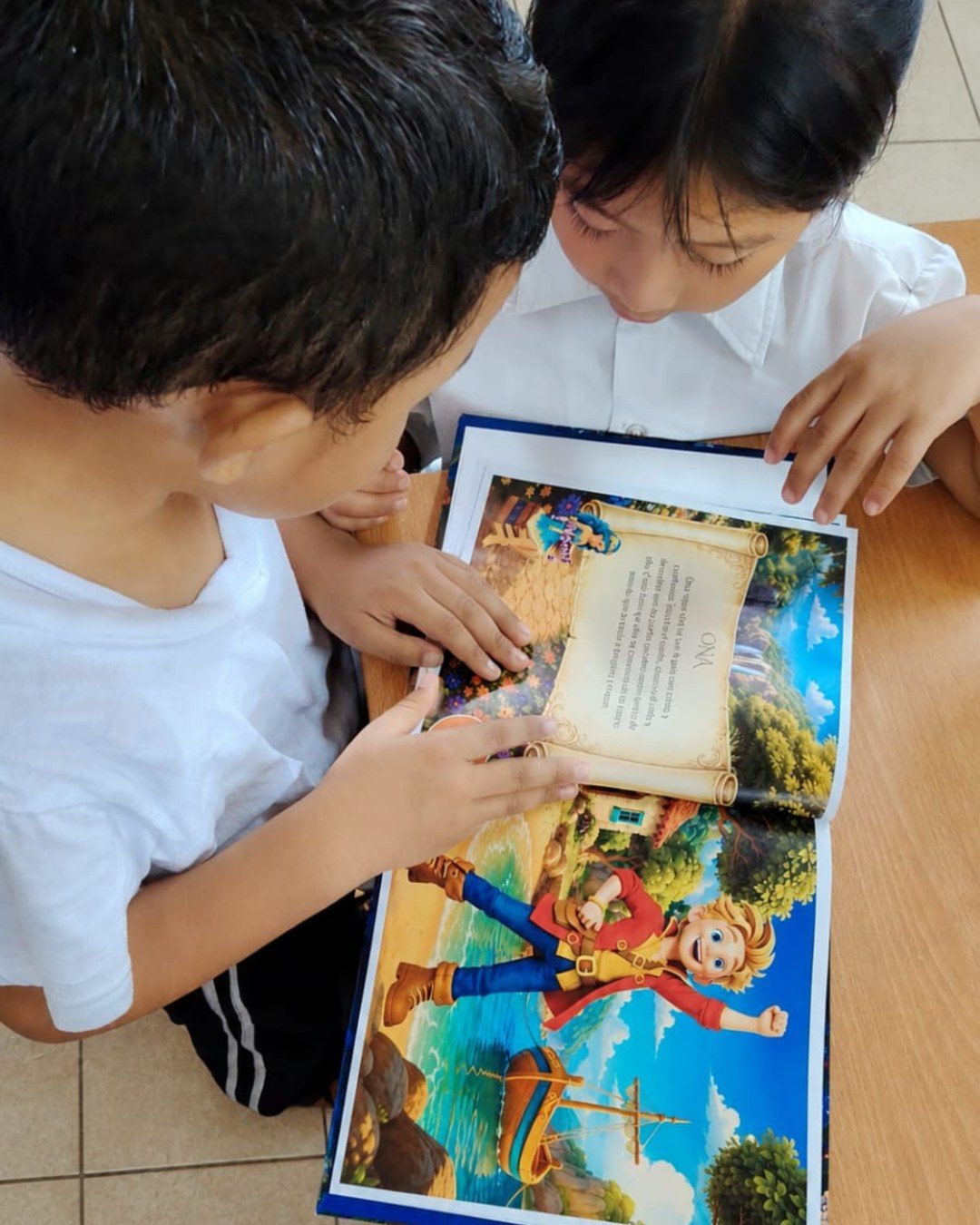 Dos niños leyendo juntos un libro de Amoravia