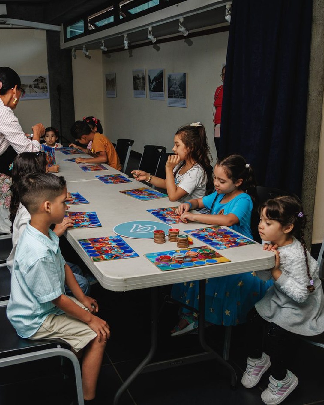 Niños trabajando con los tableros en un Sábado Mágico, con la guía al lado.