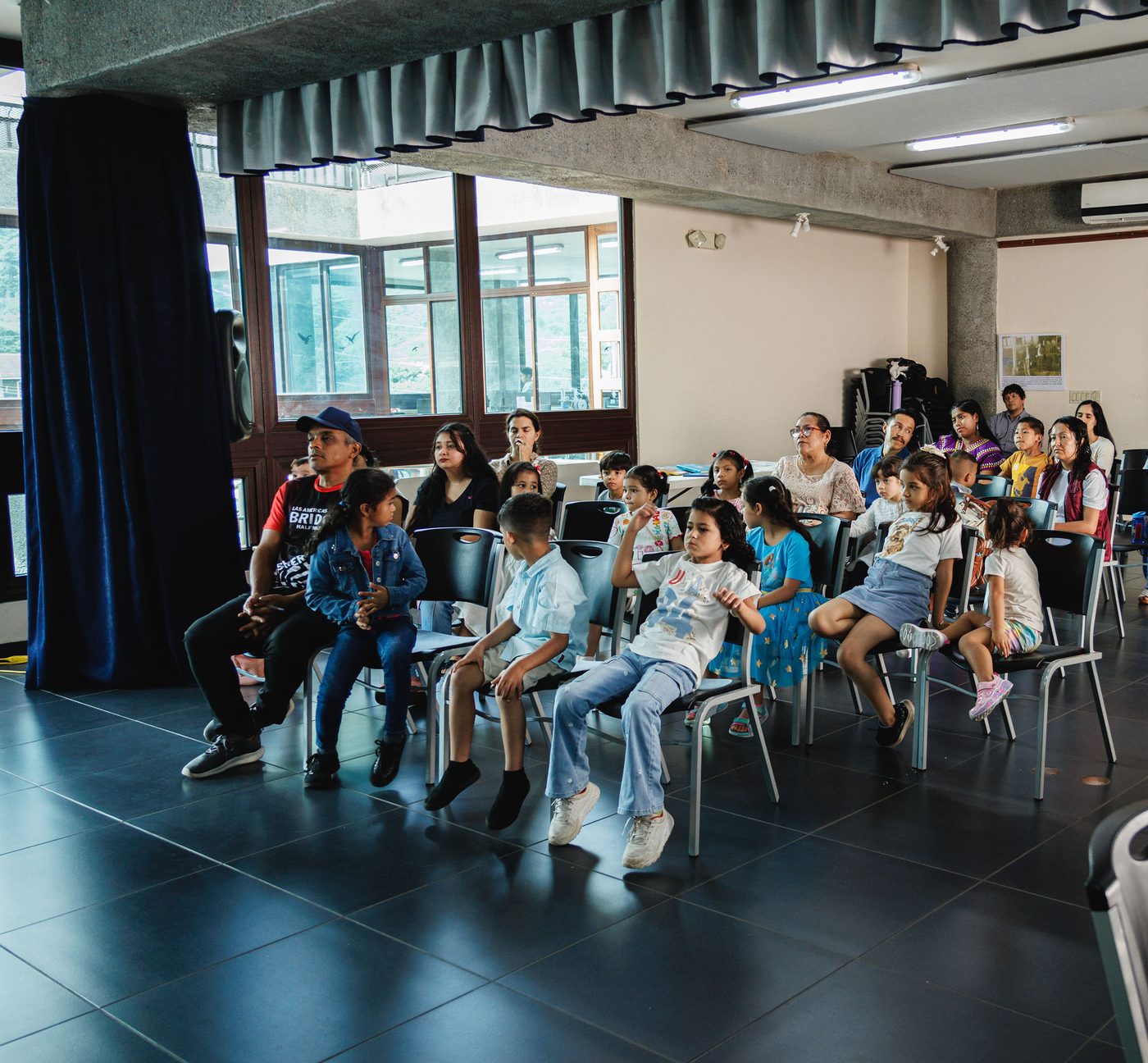 Familias siguiendo el taller desde las sillas del salón.