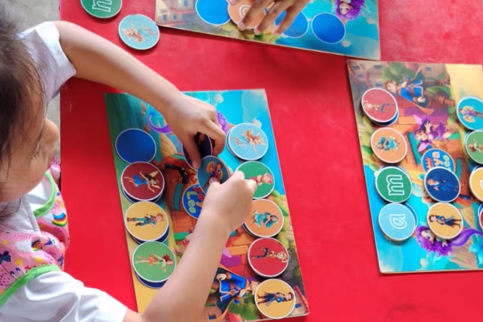 Niño trabajando con fichas y tablero físico de Yoya y Leo